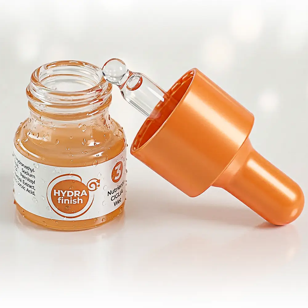 contenitore vetro cosmetico arancione aperto con tappo poggiato